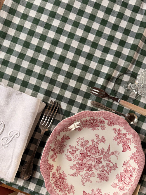 Nappe Louise à carreaux vichy vert sapin et écru, présentée avec une assiette ancienne rose à motifs floraux et une serviette brodée – Maison Bellie.